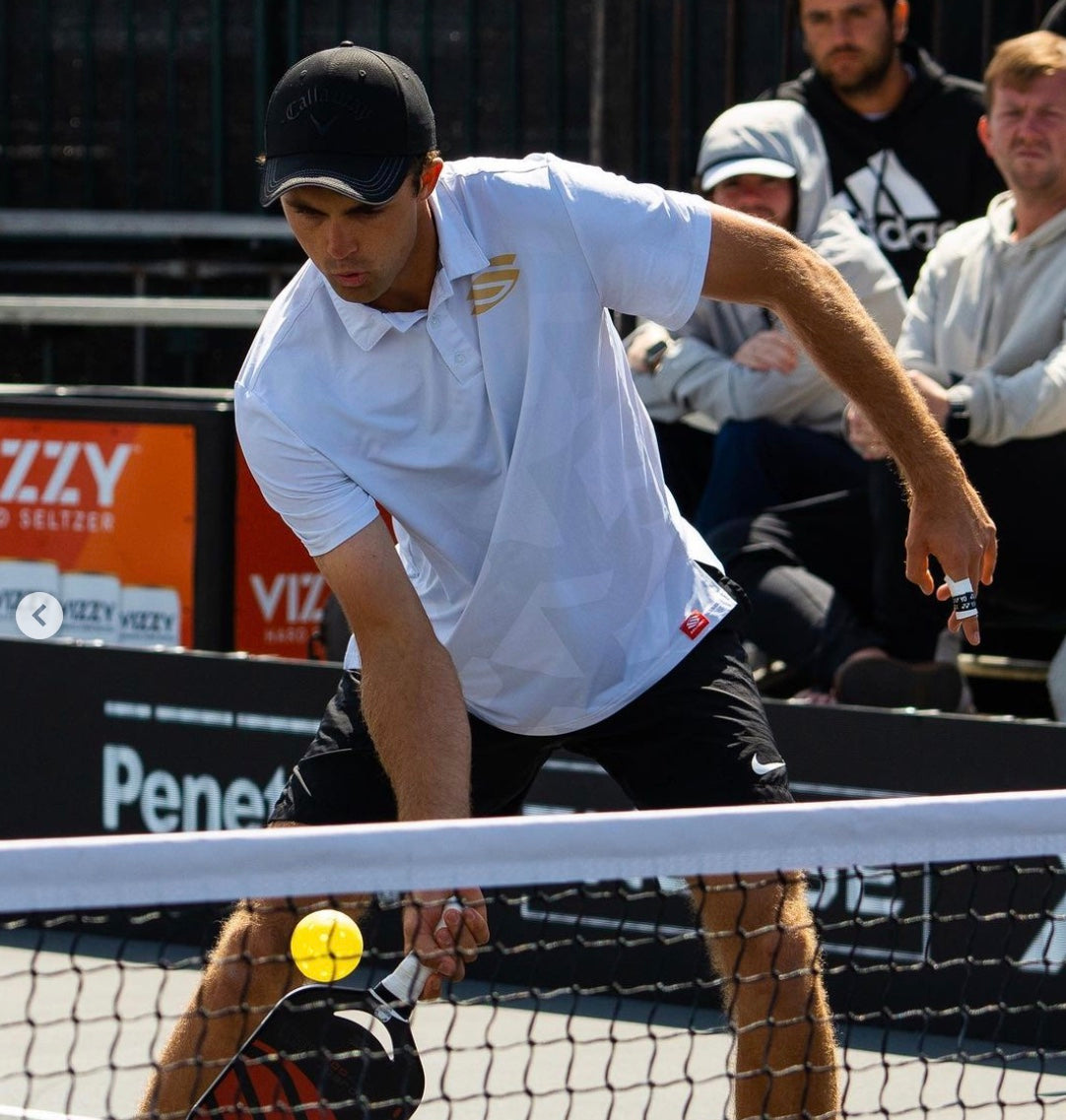 James Ignatowich playing pickleball, preparing to hit a ball near the net.