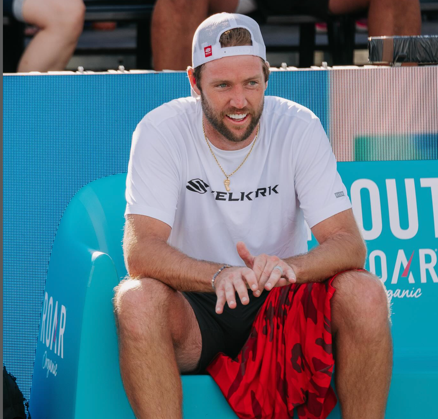 Jack Sock sitting on a bench, smiling, during the Selkirk Red Rock Open.
