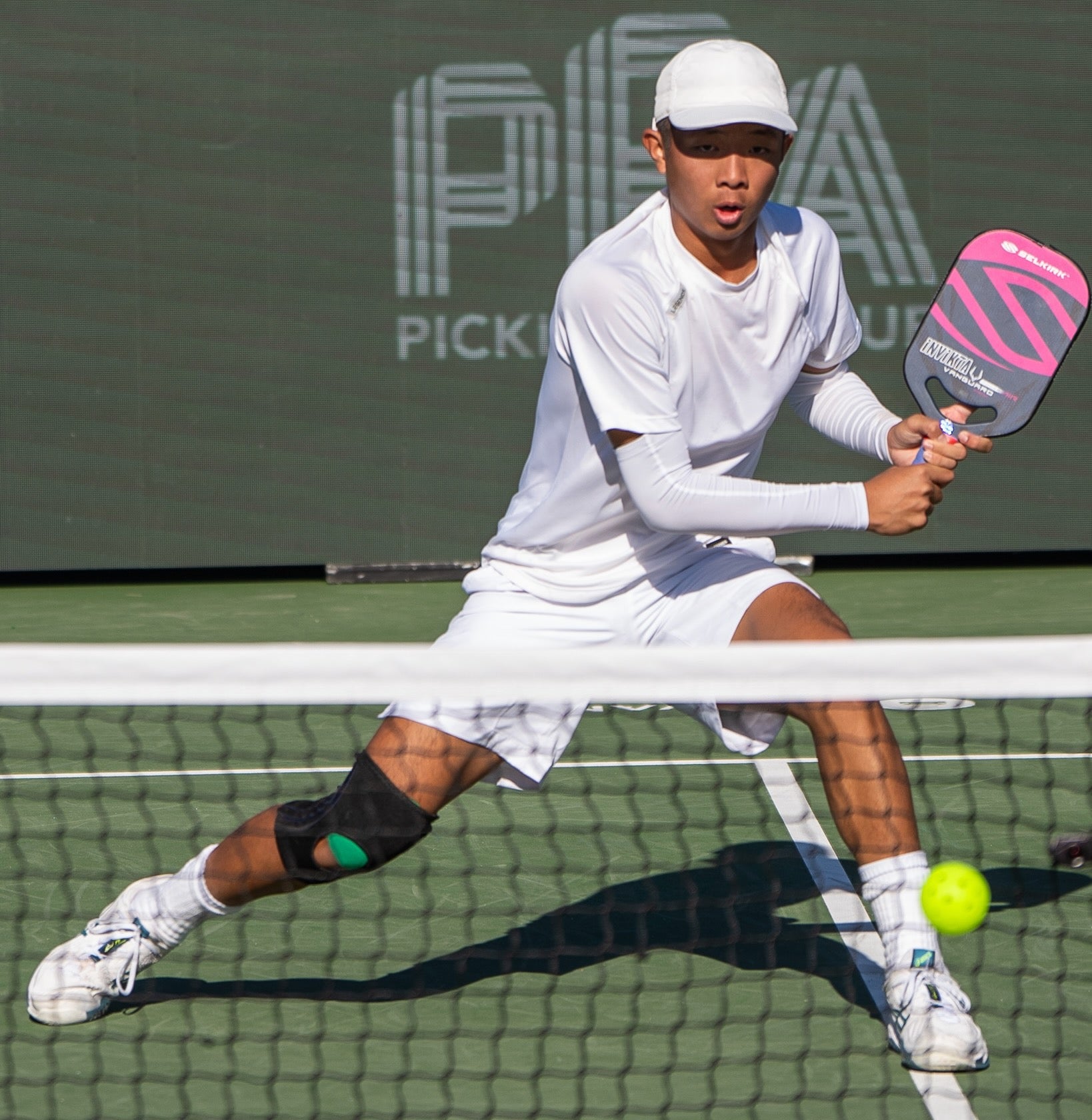 Quang Duong in action during a pickleball match, preparing to hit the ball.