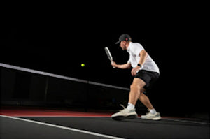 A player preparing to hit a ball on a pickleball court.