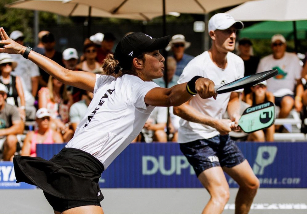 Anna Leigh Waters hitting a pickleball shot during a match, with a player in the background.