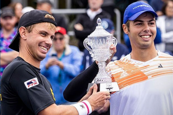 Two pickleball players celebrating with a trophy after a tournament victory.