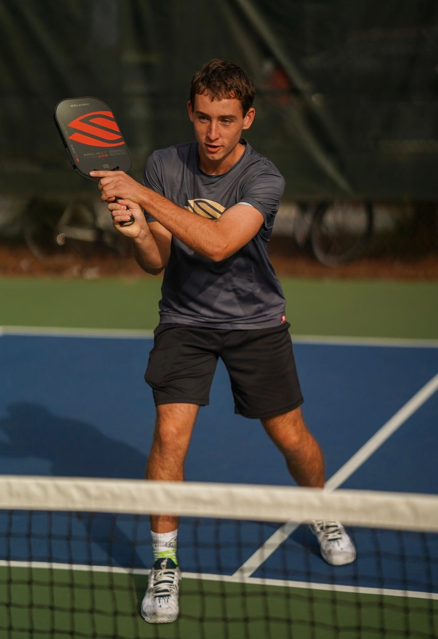 Dylan Frazier preparing to hit a pickleball during a match