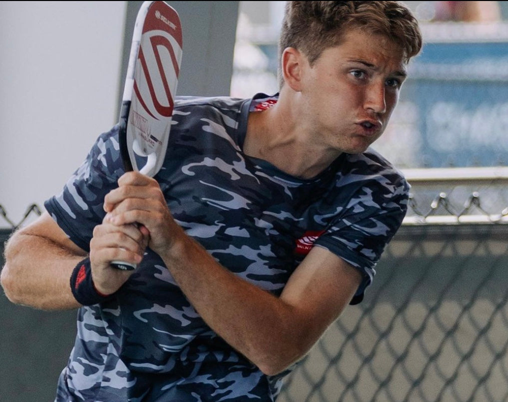 Collin Shick preparing to hit a pickleball shot during a match.