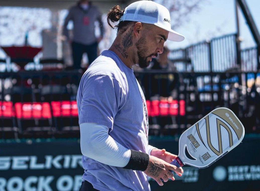 A male pickleball player holding a Selkirk paddle, preparing for a match.