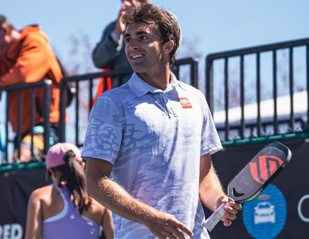 Ben Johns celebrating after a match, holding a pickleball paddle.
