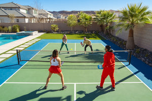 Four people play pickleball on an outdoor court beside a swimming pool