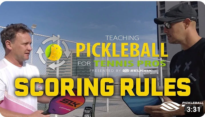 Two men discussing pickleball scoring rules with paddles and a laptop, featuring the text 'Teaching Pickleball for Tennis Pros' and 'SCORING RULES'