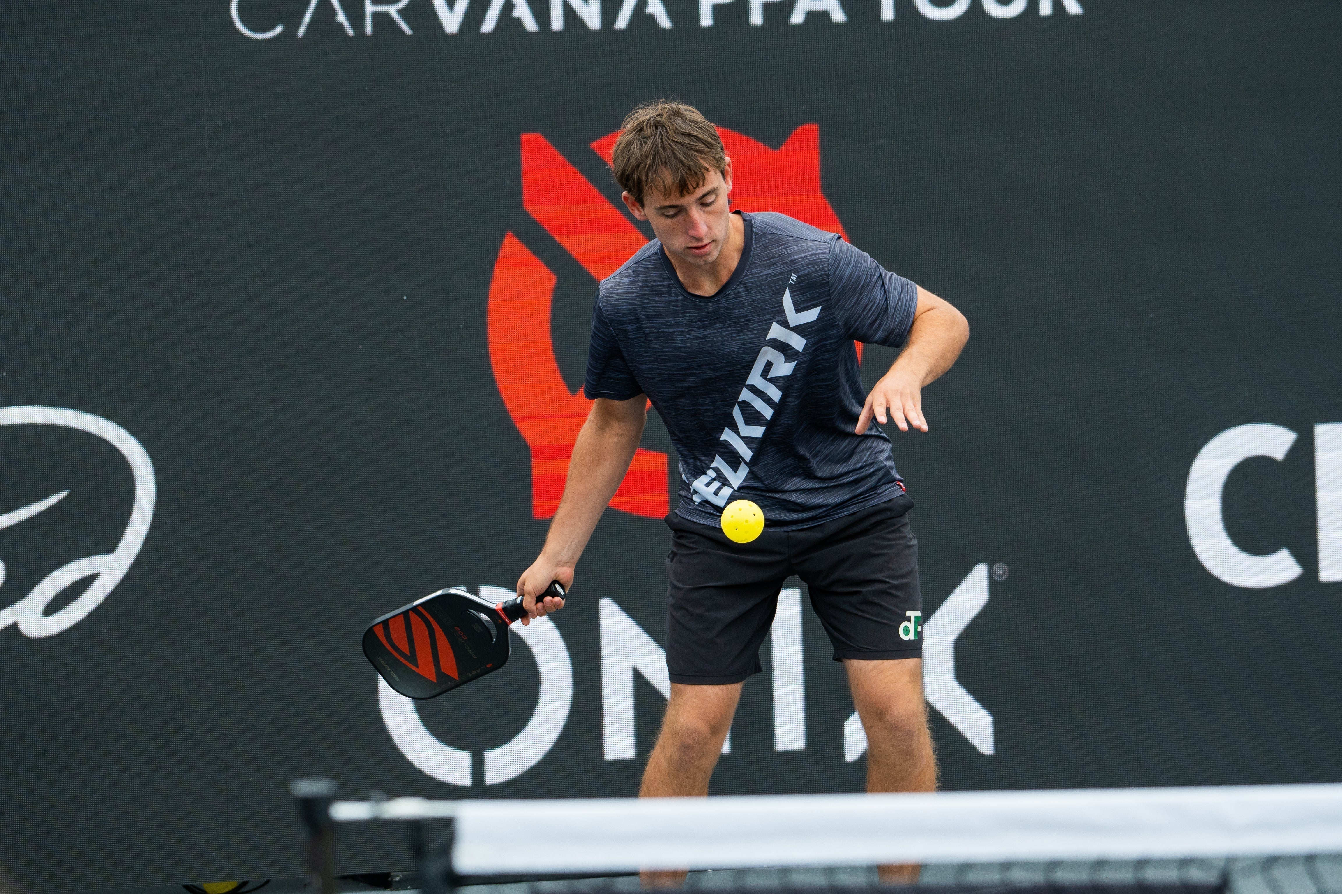 A player preparing to hit a pickleball during a game.