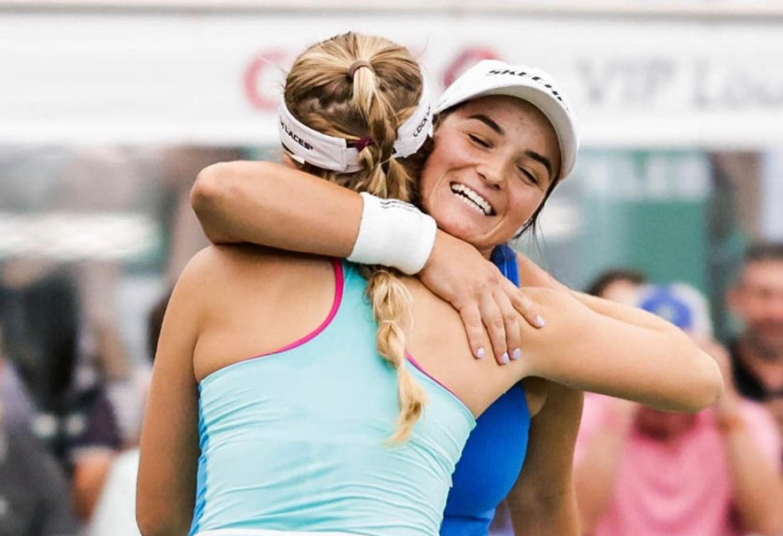 Two pickleball players embracing in celebration after a match.