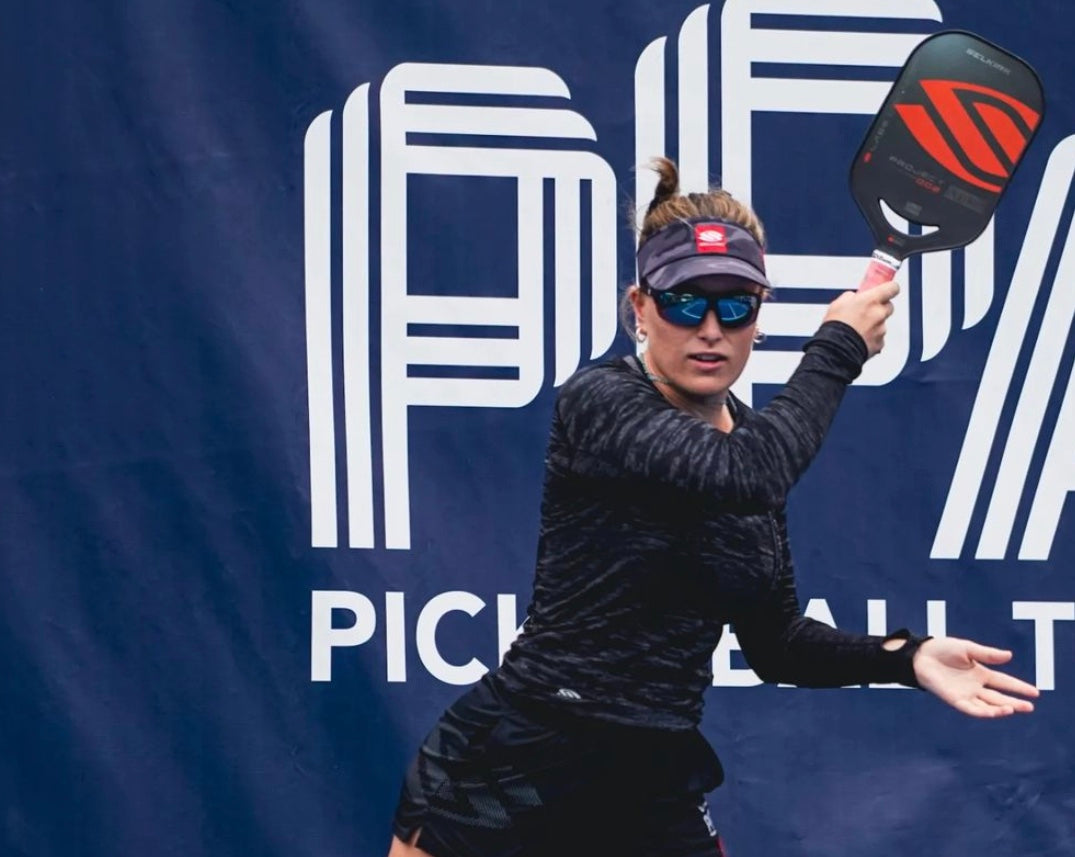 A female pickleball player preparing to hit a shot, with a PPA logo in the background.