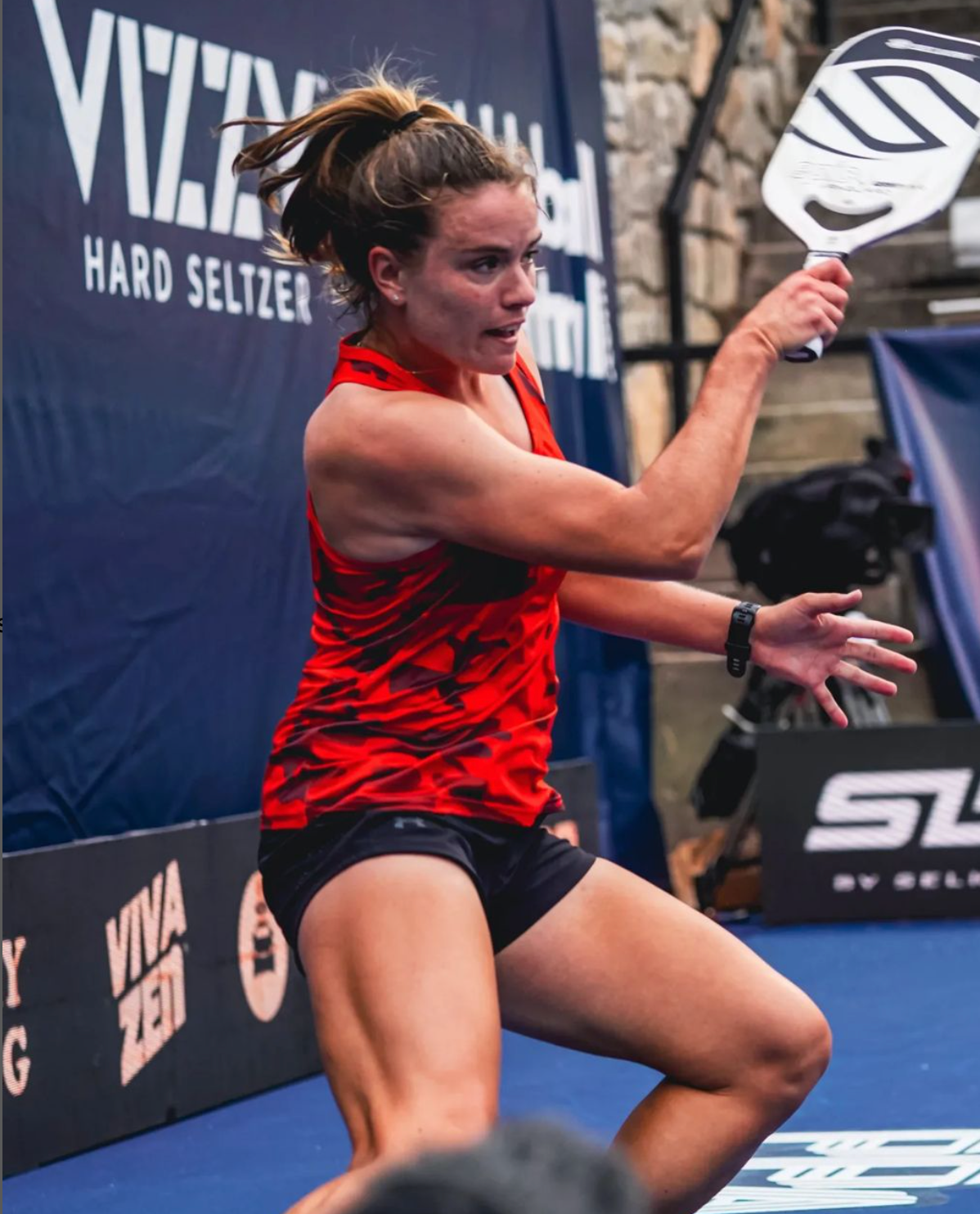 A female player in a red tank top prepares to hit a pickleball during the PPA Denver Open.