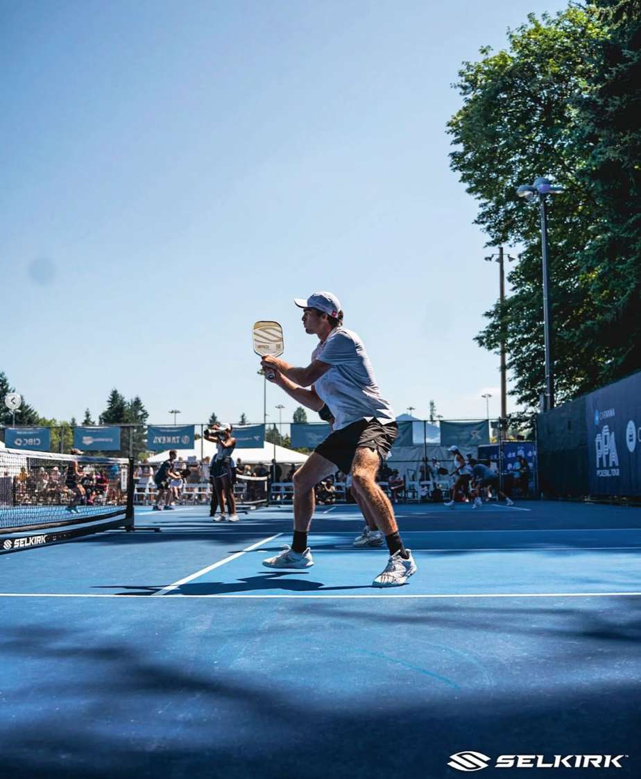 Player preparing to hit a pickleball shot on a sunny court during the PPA Seattle tournament.