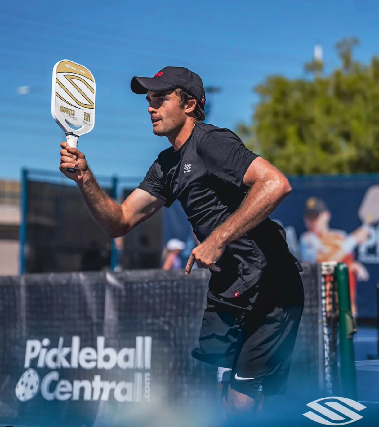 A male pickleball player in action, holding a paddle, during a match.
