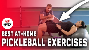 A man demonstrating a glute bridge exercise on a yoga ball with a woman performing the exercise.