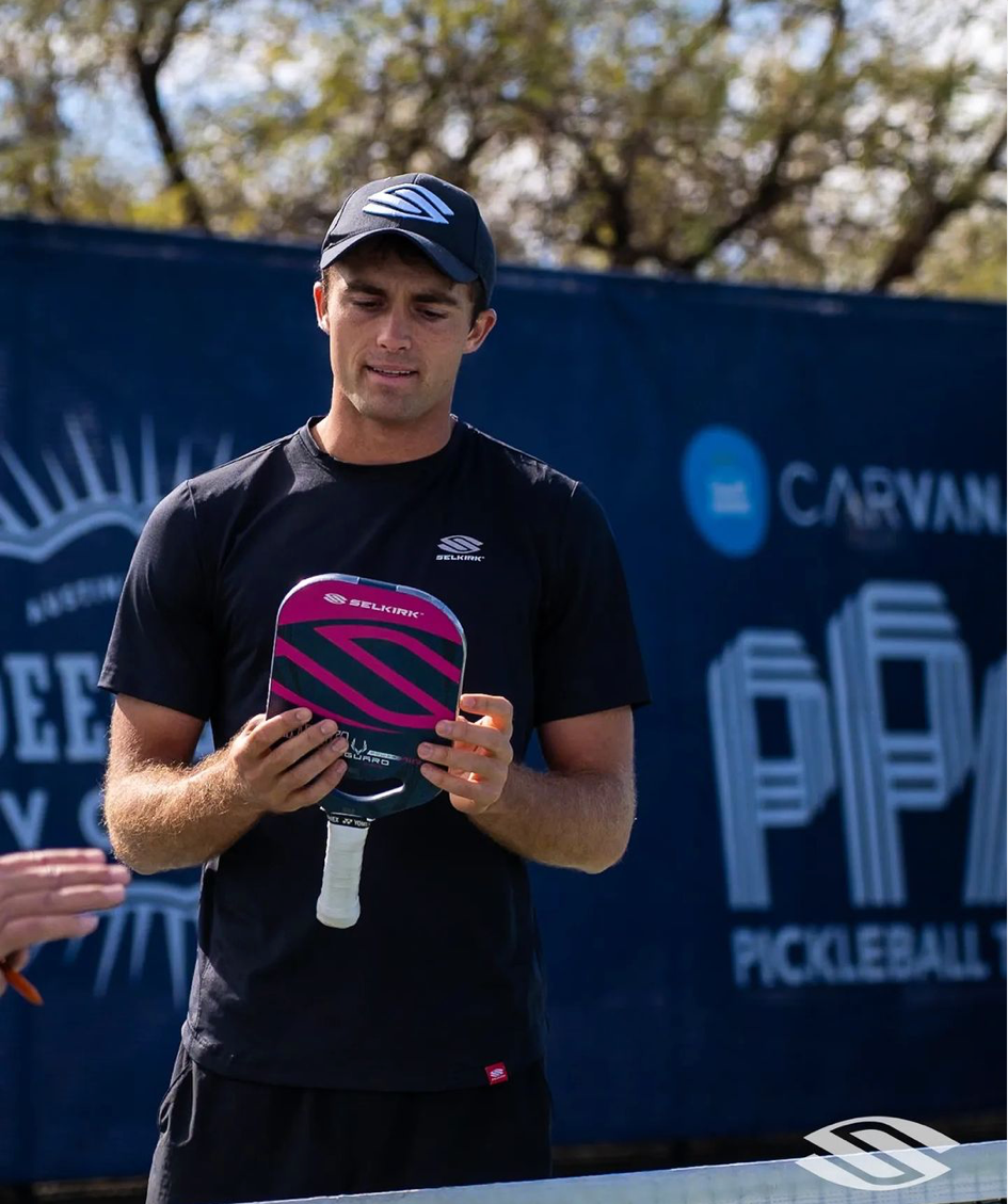James Ignatowich holding a pickleball paddle, preparing for a match