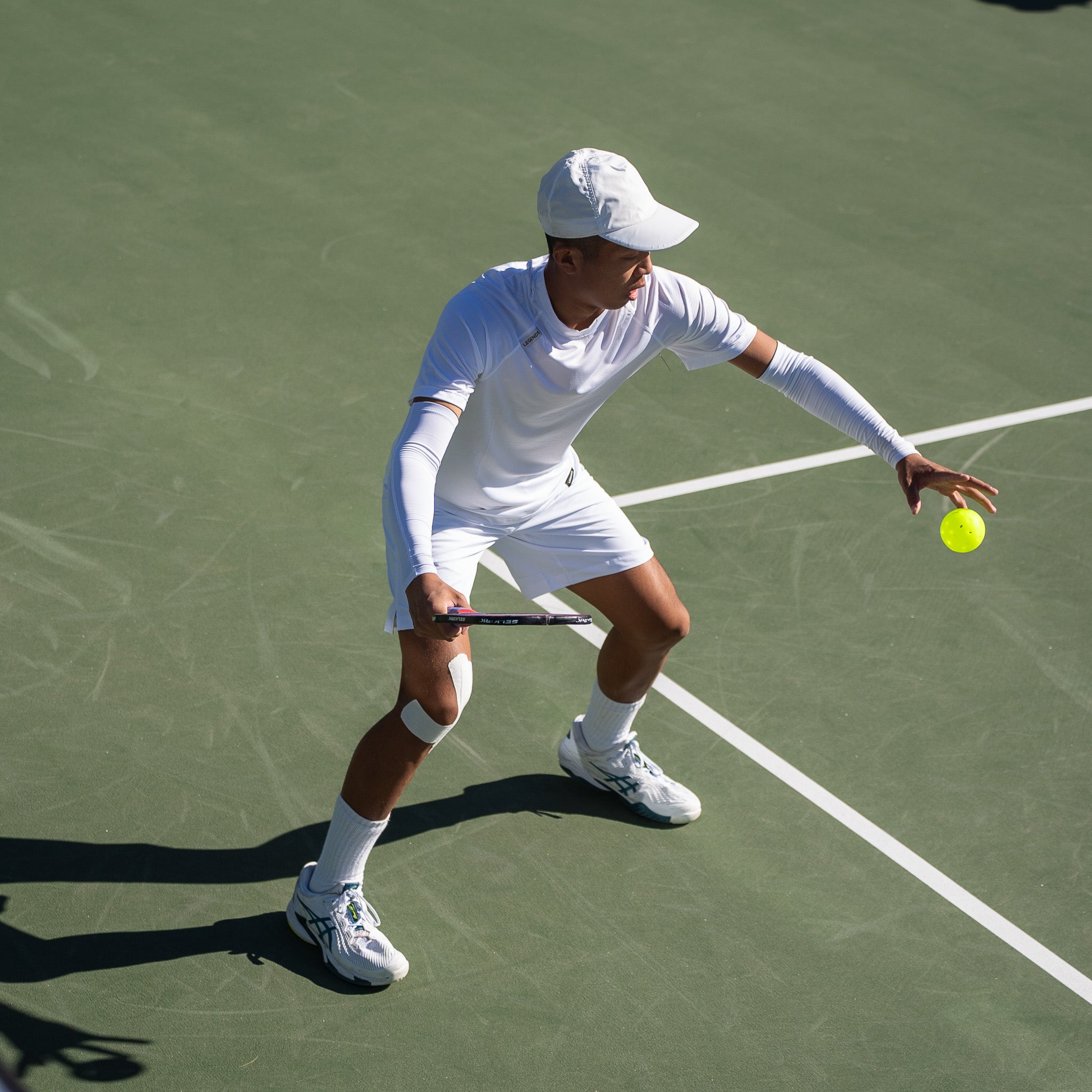 A player preparing to hit a pickleball with a paddle, demonstrating sidespin technique.