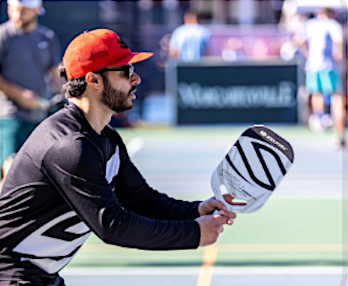 Man playing pickleball outdoors with a Selkirk VANGUARD Power Air paddle.