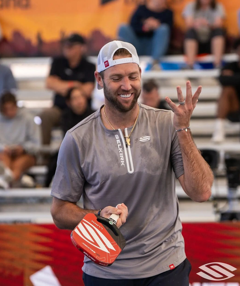 Jack Sock smiling and holding a pickleball paddle at the PPA Mesa Arizona Cup