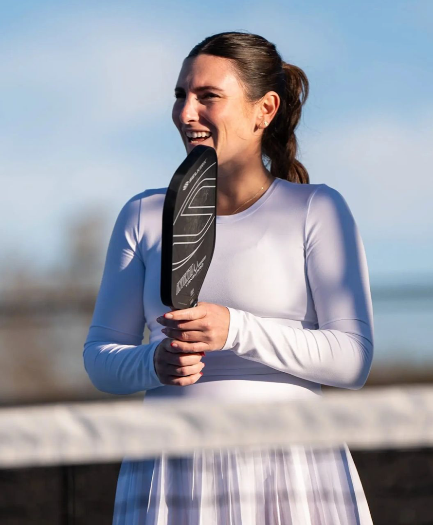 Rachel Rohrabacher smiling while holding a pickleball paddle on the court