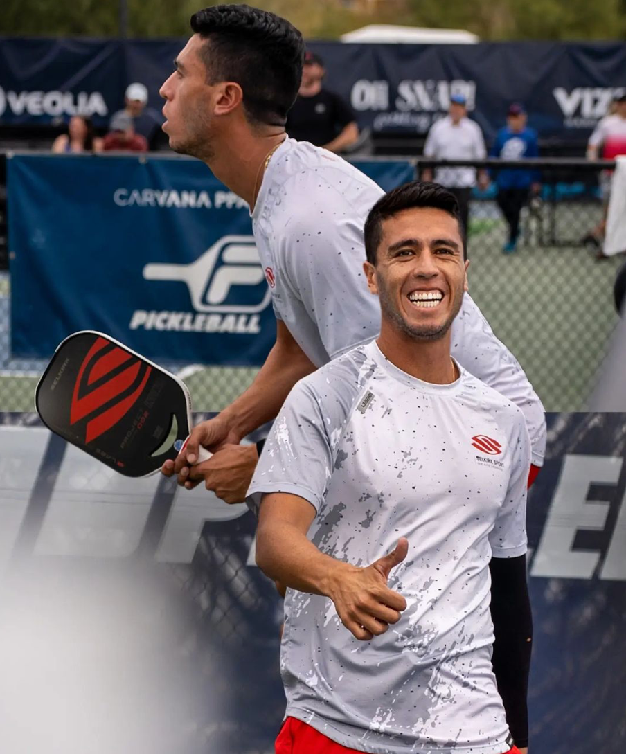 Two pickleball players celebrating during a match, one giving a thumbs up.
