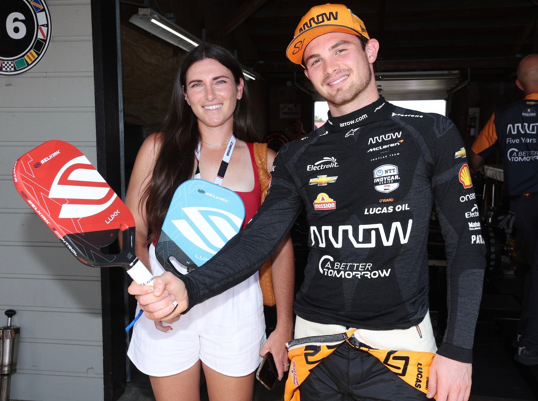 Rachel Rohrabacher and INDYCAR driver holding Selkirk Luxx Control Air paddles at the Indy 200 event.