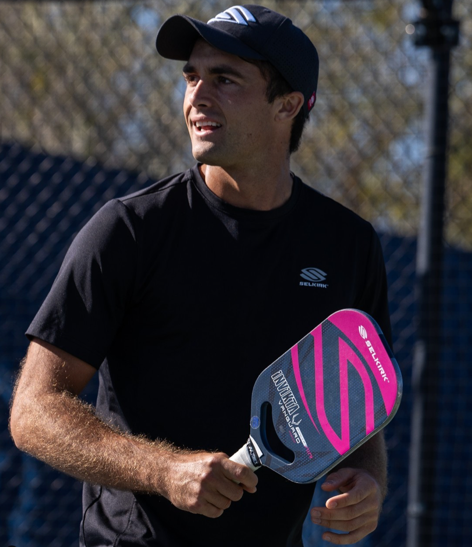 James Ignatowich holding a pickleball paddle on the court