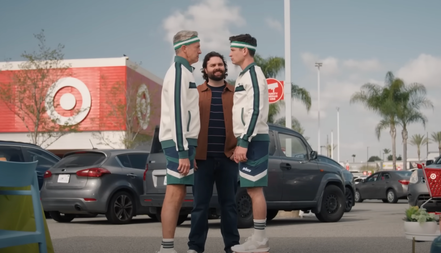 Two pickleball players in matching outfits confront a man in a parking lot.