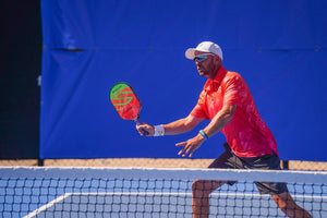 A pickleball player preparing to hit a shot at the net.