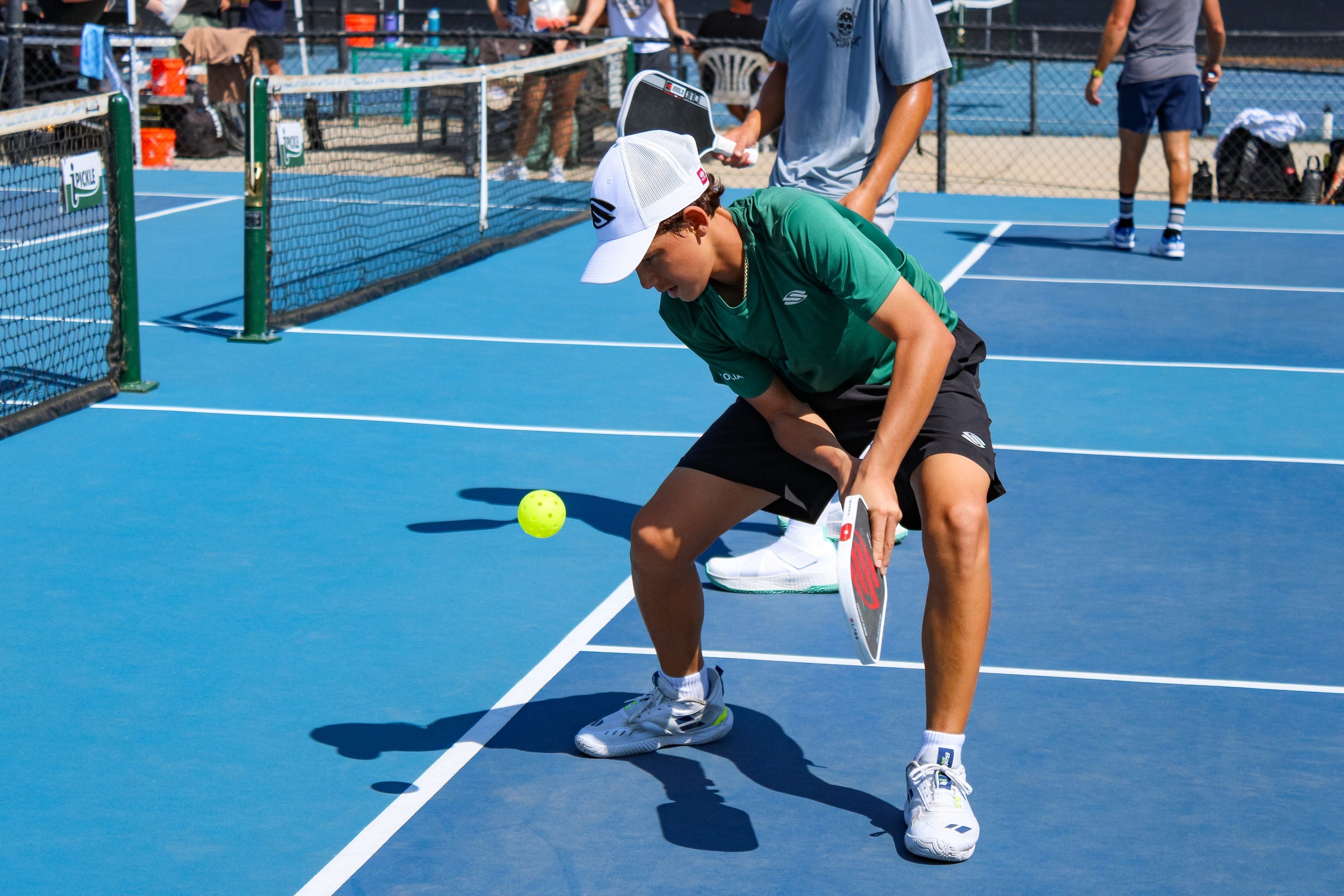 Tama Shimabukuro crouches to return a pickleball on a blue court during her MLP debut