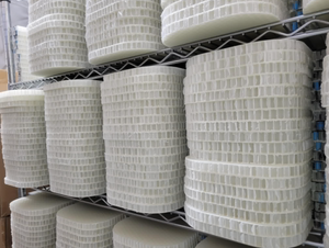 Close view of white pickleball paddle prototypes showcasing textured surfaces with warehouse shelving