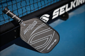 VANGUARD Control paddle resting against a net, showcasing its design and grip.