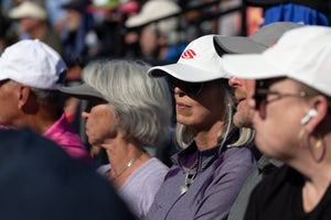 A crowd of spectators watches a pickleball match. 