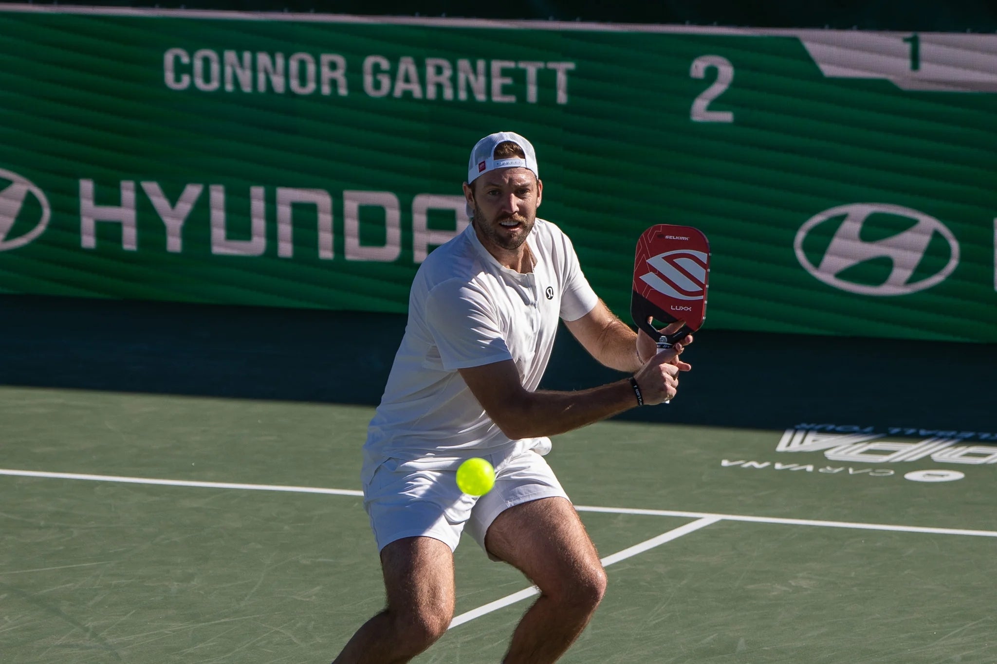 Jack Sock preparing to hit a pickleball during a match at the Pickleball Slam 2