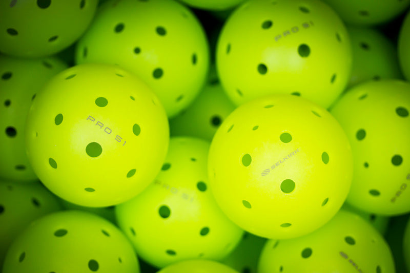 A close-up image shows a bin of Selkirk Pro S1 pickleballs. 