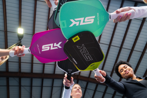 A photo shows people tapping paddles from the SLK lineup from below. 