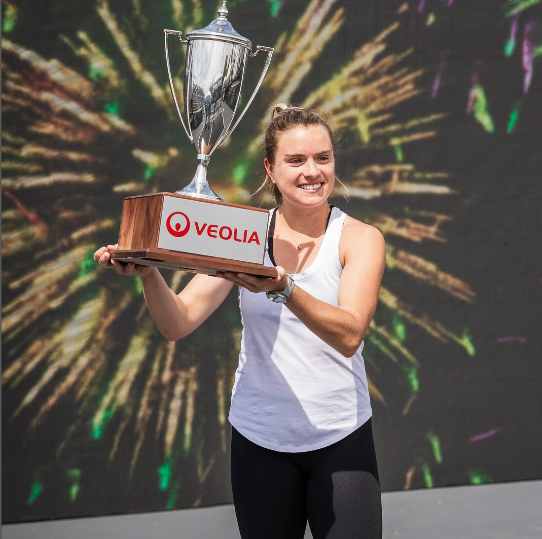 Pickleball pro Judit Castillo holding a trophy with VEOLIA logo, celebrating victory
