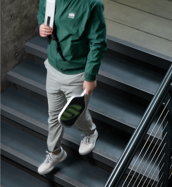 A man wears pickleball clothes and shoes as he walks to work. 