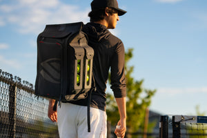Pickleball player walking across court wearing black pickleball backpack