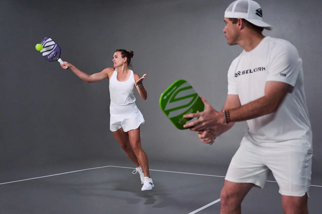 Two players demonstrating pickleball techniques with paddles on a court.