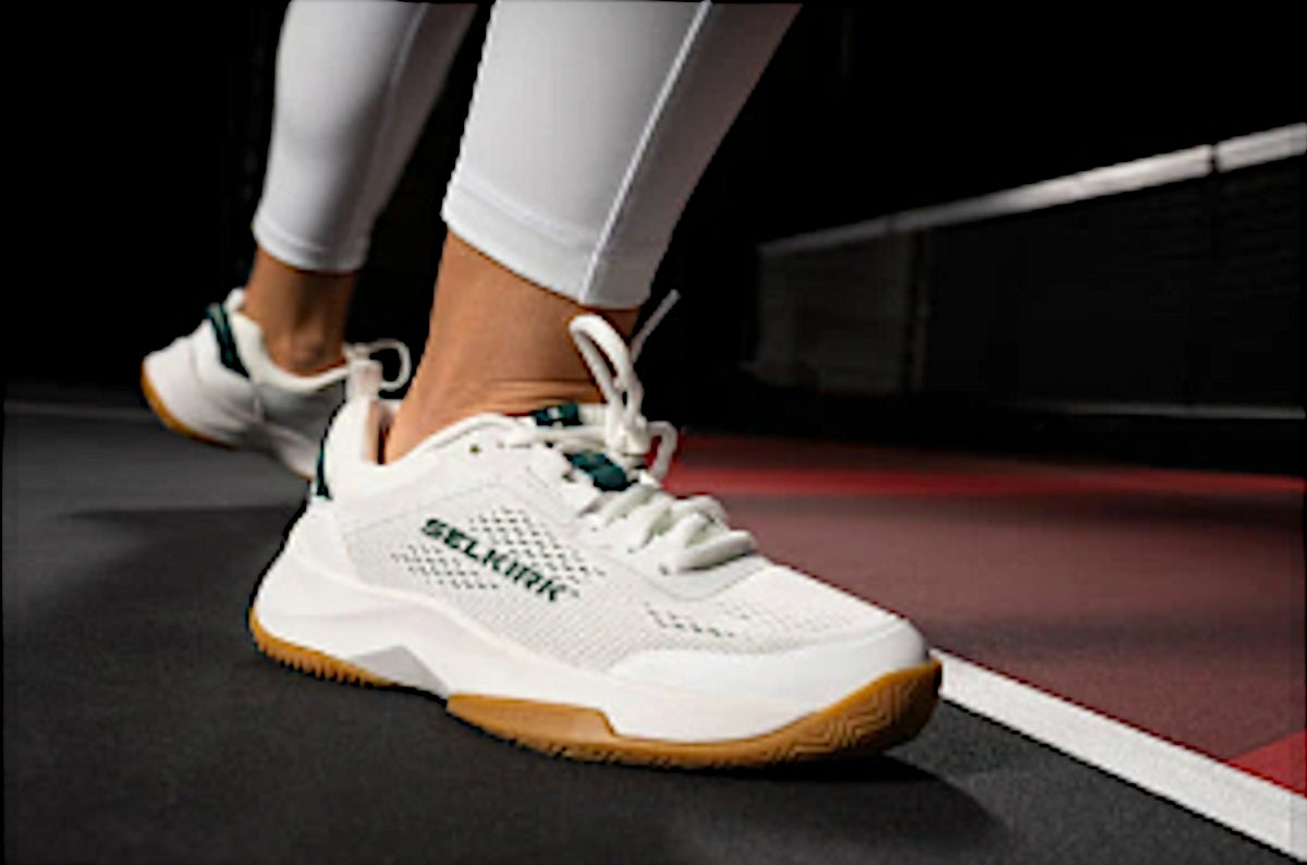 Close-up of Selkirk pickleball shoes on a court surface.
