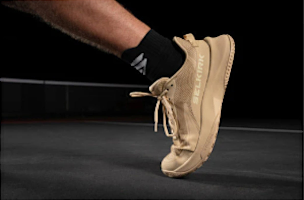 Close-up of a pickleball shoe in motion on a court surface.