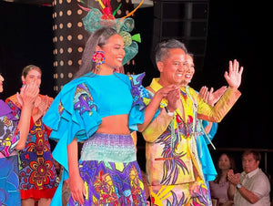 Marconi Calindas and a model wave on the runway, showcasing colorful outfits.