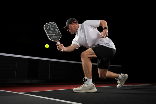 A player wearing Men's CourtStrike Pickleball Shoes, hitting a pickleball on court.