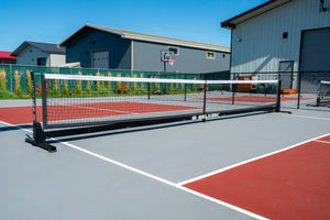 Selkirk Semi-Permanent Pro Pickleball Net set up on a court with a gray surface and red markings.