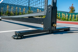 Close-up of the Selkirk Semi-Permanent Pro Pickleball Net's base and frame on a court surface.