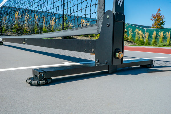 Close-up of the Selkirk Semi-Permanent Pro Pickleball Net's base and frame on a court surface.