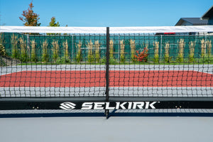 Selkirk Semi-Permanent Pro Pickleball Net with a black frame and netting on a court