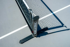 Selkirk Semi-Permanent Pro Pickleball Net with a black frame and net on a court surface