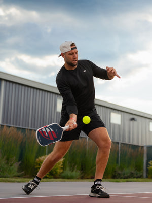 Jack Sock hitting a low forehand with the Boomstik Jack Sock Signature paddle